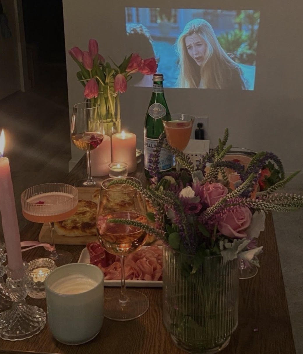 An assortment of food and beverages with a movie on the project screen